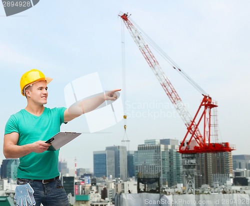 Image of smiling man in helmet with clipboard