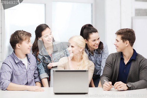 Image of smiling students with laptop at school