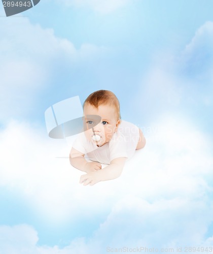 Image of smiling baby lying on cloud with dummy in mouth