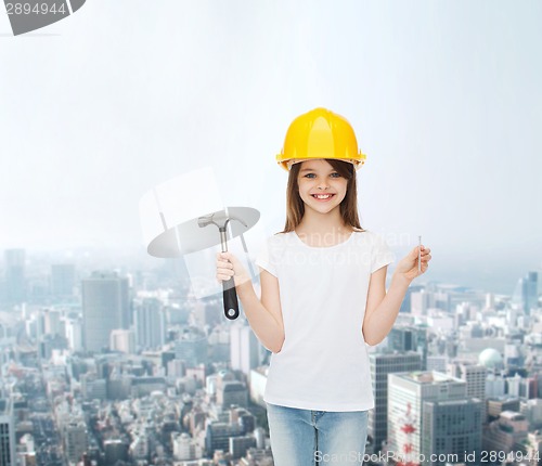 Image of smiling little girl in hardhat with hammer