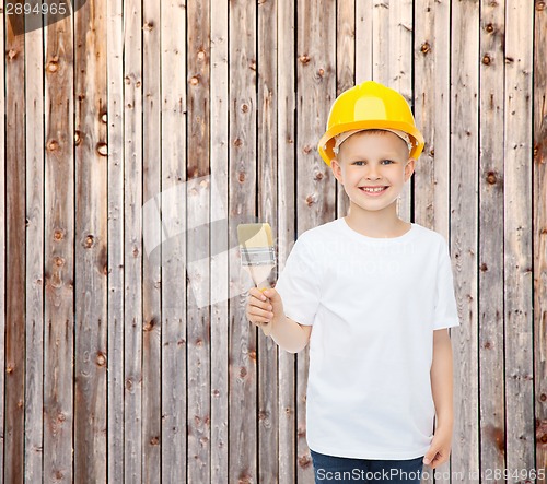 Image of smiling little boy in helmet with paint brush