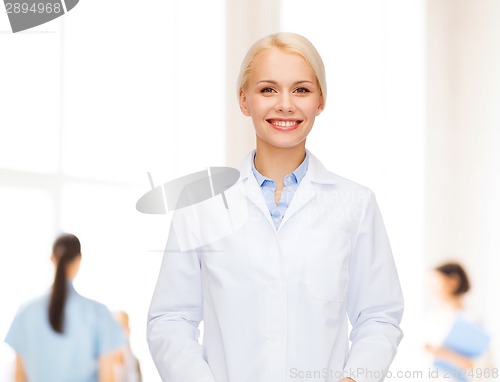 Image of smiling female doctor with group of medics