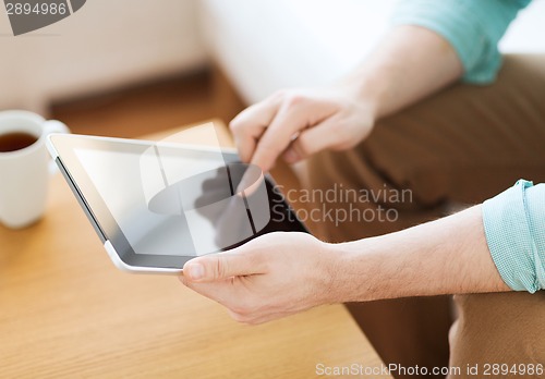 Image of close up of man with laptop and cup at home