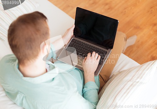 Image of close up of man working with laptop at home