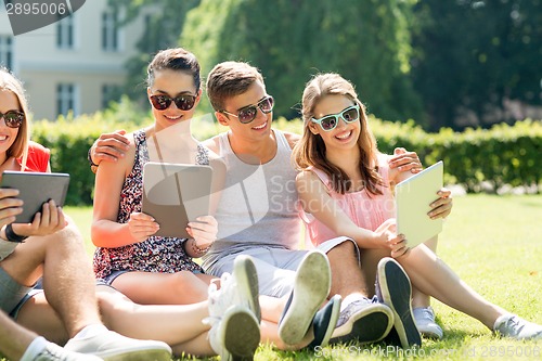 Image of smiling friends with tablet pc computers in park