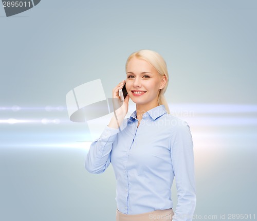 Image of young smiling businesswoman with smartphone