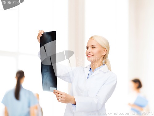 Image of smiling female doctor looking at x-ray