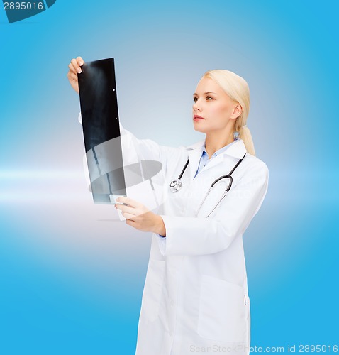 Image of serious female doctor looking at x-ray