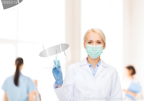 Image of doctor in mask holding syringe with injection