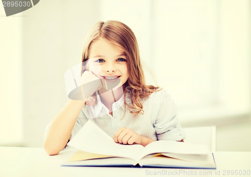 Image of little student girl studying at school