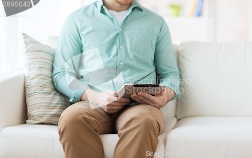 Image of close up of man with tablet pc computer at home