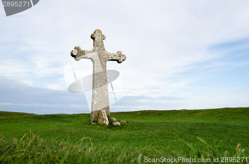 Image of Ancient cross surrounded of green grass