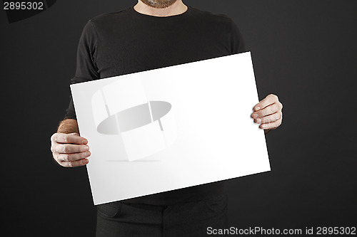 Image of Man holds up poster