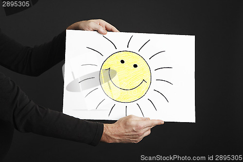 Image of Man holding billboard with sun