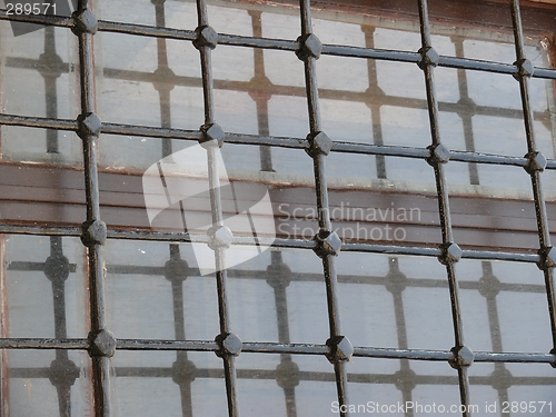 Image of Close up of dirty glass window behind iron bars