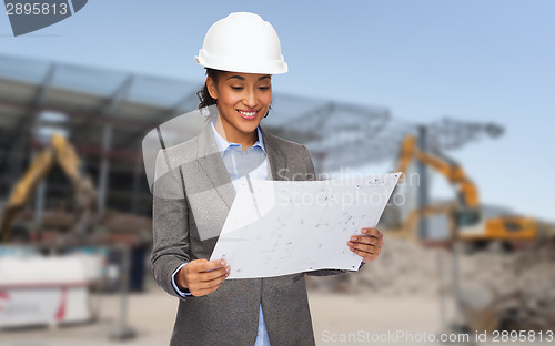 Image of businesswoman in white helmet with blueprint