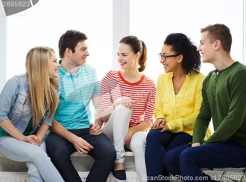 Image of five smiling teenagers having fun at home