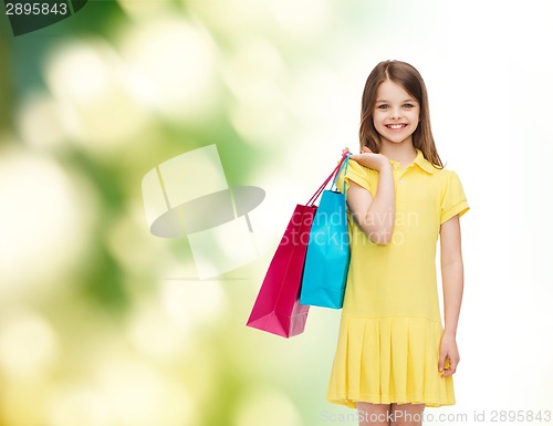 Image of smiling little girl in dress with shopping bags