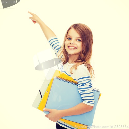 Image of cute girl with folders pointing at virtual screen
