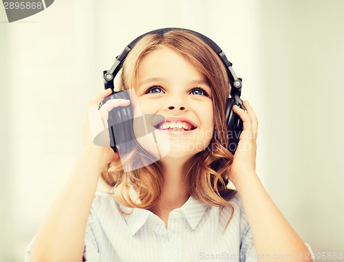 Image of little girl with headphones at home