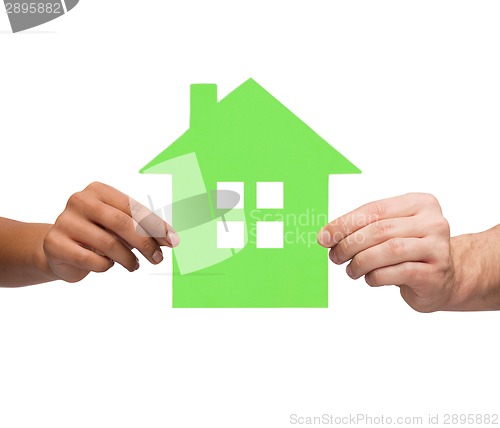 Image of couple hands holding green house