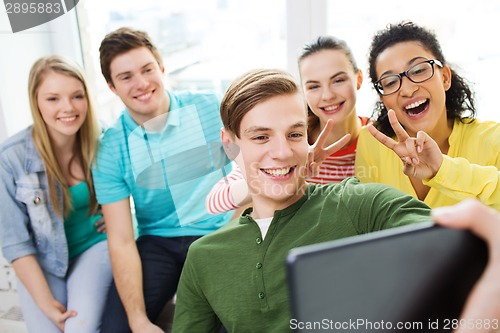 Image of smiling students making selfie with tablet pc