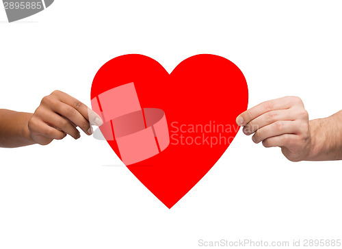 Image of couple hands holding red heart