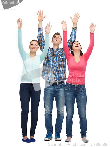 Image of group of smiling teenagers with raised hands