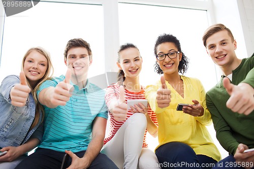 Image of smiling students with smartphone texting at school