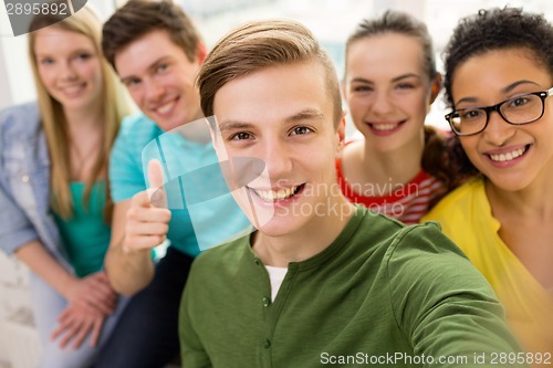 Image of five smiling students taking selfie at school