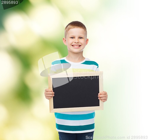 Image of smiling little boy holding blank black chalkboard