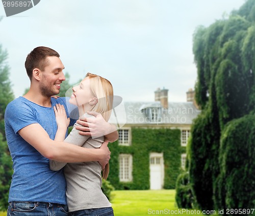 Image of smiling couple hugging and looking at each other