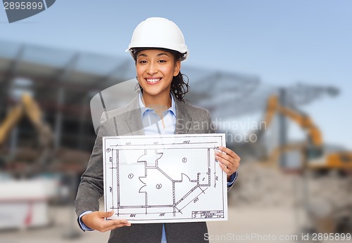 Image of businesswoman in white helmet with blueprint