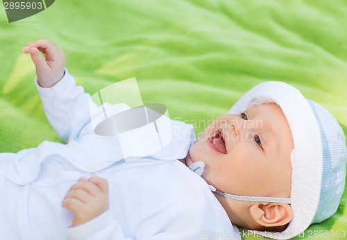 Image of smiling baby lying on floor and looking up