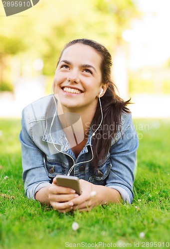Image of smiling young girl with smartphone and earphones