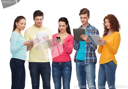 Image of group of teenagers with smartphones and tablet pc