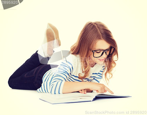 Image of smiling little student girl lying on the floor