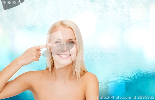 Image of beautiful woman touching her eye area