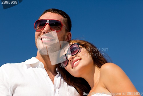 Image of smiling couple over blue sky background