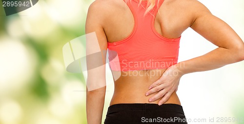 Image of close up of sporty woman touching her back