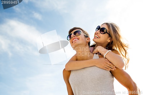 Image of smiling couple having fun over sky background