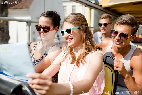 Image of group of smiling friends traveling by tour bus