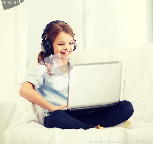 Image of girl with laptop computer and headphones at home