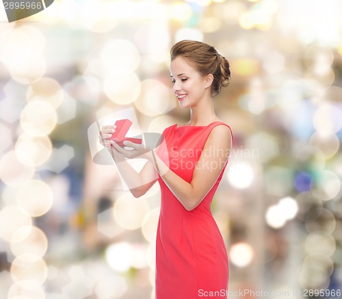 Image of smiling young woman in red dress with gift box