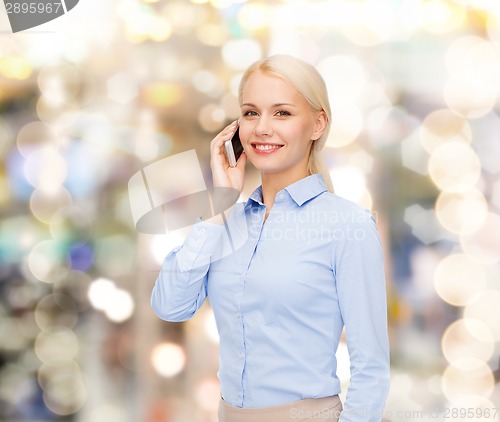 Image of young smiling businesswoman with smartphone