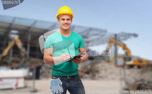 Image of smiling man in helmet with clipboard