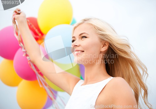 Image of woman with colorful balloons outside