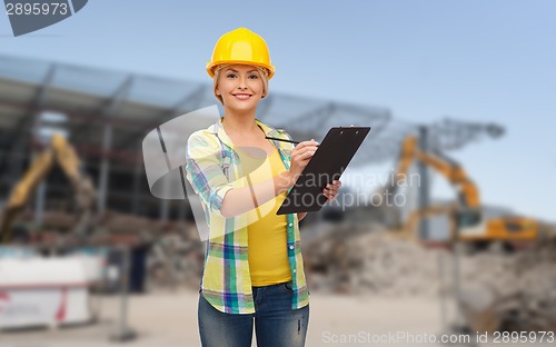 Image of smiling woman in helmet with clipboard