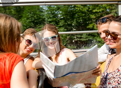 Image of group of smiling friends traveling by tour bus