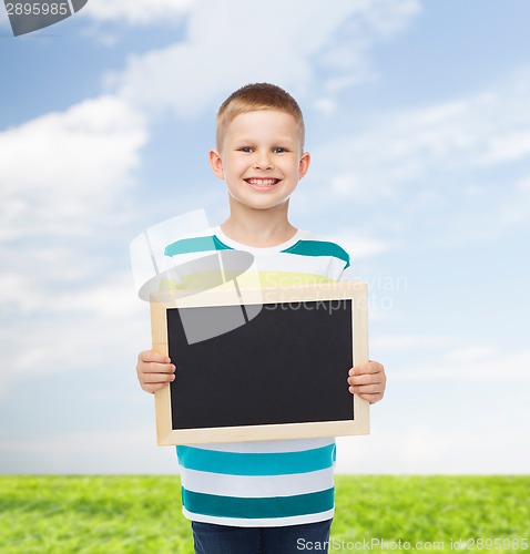 Image of smiling little boy holding blank black chalkboard